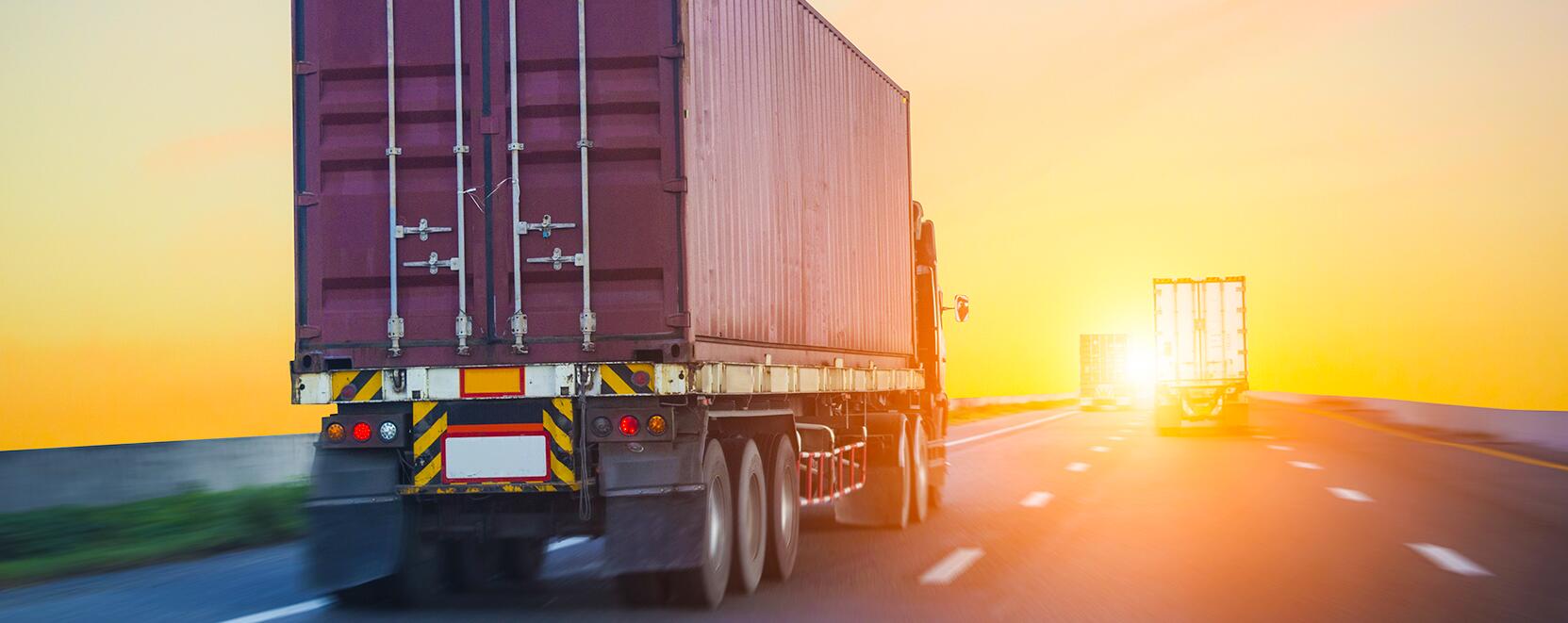 Trucks driving on highway during golden hour